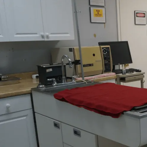 Strawbridge Animal Care's medical room 1 where there is table and a red towel on top of it.  There are medical equipment on a counter and computer in the room.